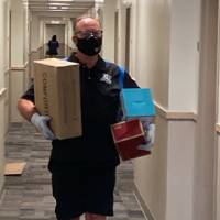 Dr. Huizen carries items into a residence hall